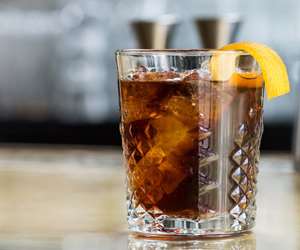 Rocks glass cocktail garnished with expressed orange