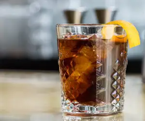 Rocks glass cocktail garnished with expressed orange