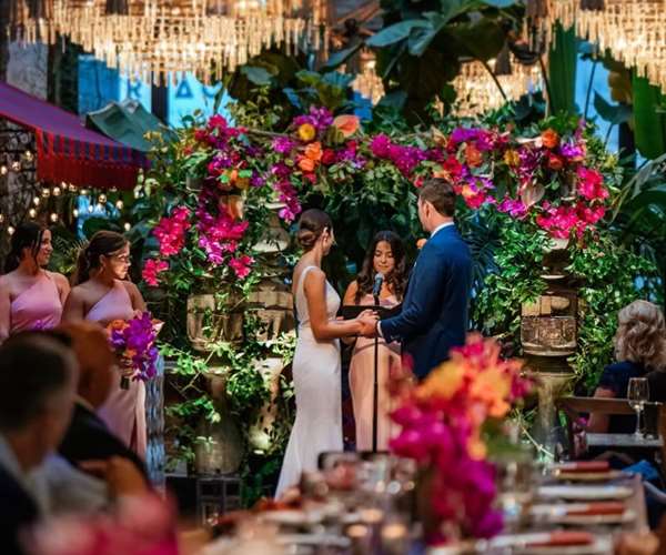Bride and Groom beneath arch of flowers